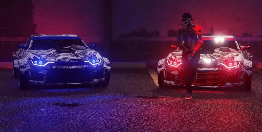 Two matching liveried sports cars under blue and red lights, with a masked crew member leaning on one